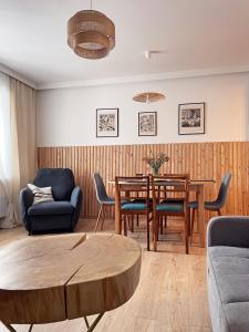 APARTAMENT Pod Lasem Jedlina Zdrój في جيدلينا زدروي: غرفة معيشة مع طاولة وكراسي