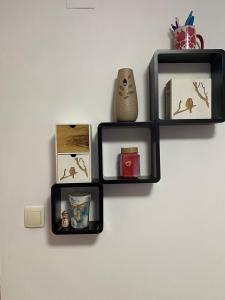 a wall with three black shelves on a wall at Apartman Stanić in Bosanska Gradiška