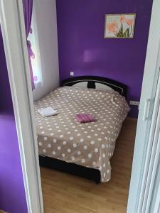 a small bedroom with a bed in a purple room at Apartman Stanić in Bosanska Gradiška