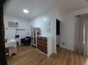 a living room with a dresser and a mirror at Lindissíma casa com piscina Blumenau próx praias in Blumenau