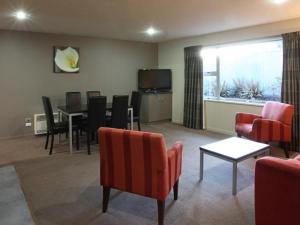 a living room with a table and chairs and a dining room at 388 Tay Motel in Invercargill