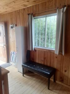 Habitación con banco frente a una ventana en El Refugio de la Estancia, en Isla Negra