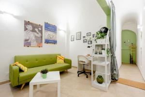 sala de estar con sofá verde y mesa en Lungarno 7 Pisa, en Pisa
