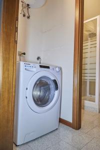 uma máquina de lavar roupa branca num quarto com uma porta em Alloggio centro Monza em Monza