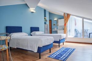 Duas camas num quarto com paredes azuis em Alloggio centro Monza em Monza
