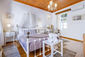 a bedroom with a white bed with a wooden ceiling at villa Yiannoula in Skopelos Town