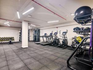 un gimnasio con filas de cintas de correr y bicicletas estáticas en Livensa Living Studios - Valencia Viveros, en Valencia