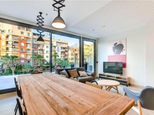 uma sala de estar com uma mesa de madeira e uma grande janela em Livensa Living Studios - Valencia Viveros em Valência