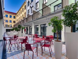 een patio met rode tafels en stoelen op een binnenplaats bij Livensa Living Studios - Valencia Viveros in Valencia