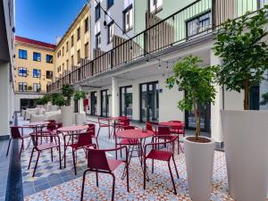 a patio with red tables and chairs in a courtyard at Livensa Living Studios - Valencia Viveros in Valencia