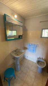 W łazience znajduje się umywalka, toaleta i lustro. w obiekcie Tannenberg Casa de época w mieście El Bolsón