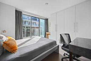 a bedroom with a bed and a desk and a window at Sleek 2BD Flat wTerrace - 2 Mins from Farringdon! in London