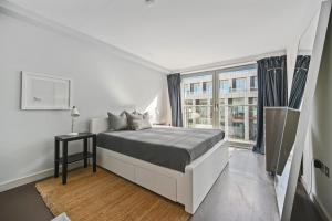 a bedroom with a bed and a large window at Sleek 2BD Flat wTerrace - 2 Mins from Farringdon! in London