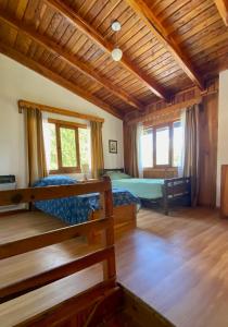 1 dormitorio con 2 camas en una habitación con techos de madera en Tannenberg Casa de época en El Bolsón