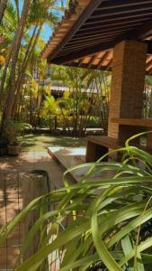 a patio with a bench and plants in a garden at Itacimirim Villas da Praia in Camacari
