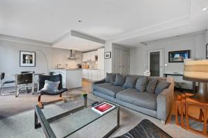 a living room with a couch and a table at Sleek 2BD Flat wTerrace - 2 Mins from Farringdon! in London
