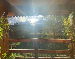 vistas al sol desde el porche de una cabaña en Tannenberg Casa de época en El Bolsón