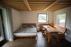 - une chambre avec un lit et une table en bois dans l'établissement Haus Oberwössen, à Unterwössen