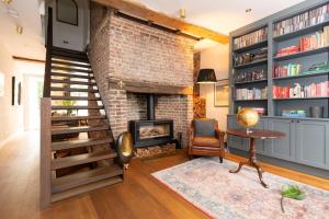 a living room with a fireplace and a brick wall at Elegant & Modern 5BD Home w Garden - Greenwich! in London