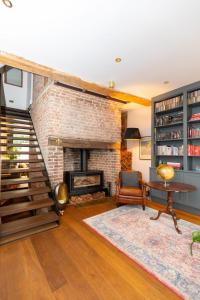 a living room with a fireplace and a brick wall at Elegant & Modern 5BD Home w Garden - Greenwich! in London