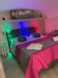 een slaapkamer met een bed met roze en groene verlichting bij B&B di Kekka in Napels