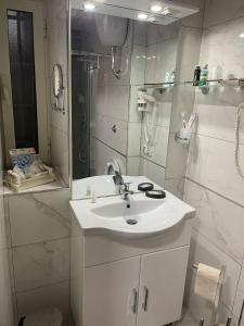 een witte badkamer met een wastafel en een douche bij B&B di Kekka in Napels