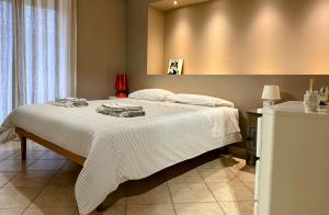 sypialnia z dużym łóżkiem z białą pościelą w obiekcie Casa Cavour w mieście Misterbianco