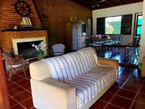 a living room with a couch and a fireplace at Conforto de casa de campo, ao lado da praia ! in Guarujá