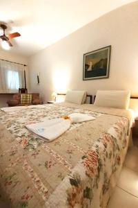 a bedroom with a large bed with a flowered blanket at Pousada e SPA Canto do Mar in Guarujá