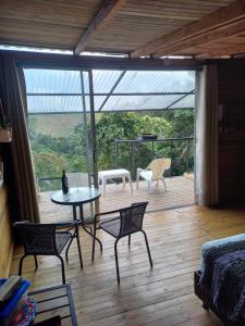 een patio met een tafel en stoelen op een houten terras bij Ecohousing Del Bosque in San Rafael