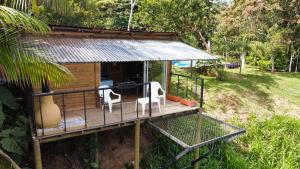 een klein huis met een terras met twee stoelen bij Ecohousing Del Bosque in San Rafael