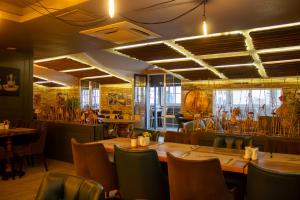 Hotel Zade في أرزروم: مطعم فيه طاولات وكراسي في الغرفة