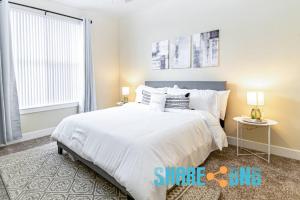 a bedroom with a large white bed and a window at Twin Apartments-great For Groups in Dallas