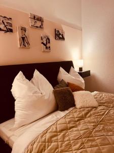 Schlafzimmer mit einem Bett mit Kissen und Bildern an der Wand in der Unterkunft Charmante Ferienwohnung in Dresden Striesen - Frau Pie Appartement in Dresden