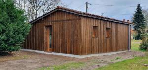 un pequeño edificio de madera con puerta y ventanas en Pavillon de la biche, en Commensacq