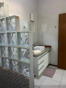 a bathroom with a sink and a mirror at Casa Espaçosa em Arraial D”Ajuda in Porto Seguro