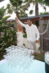 una sposa e uno sposo in piedi accanto a un tavolo con bicchieri da vino di SI COMO NO INN a Flagler Beach
