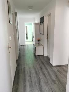 an empty hallway with white walls and wood floors at Apartment PETRA Mojstrana in Mojstrana