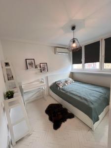 a white bedroom with a bed and a window at Scandinavian Retkinia Distric in Łódź