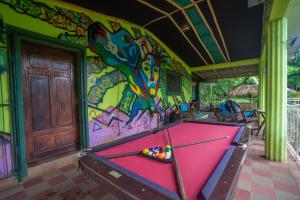a pool table in front of a wall with graffiti at Huellas Hostel in Santa Cruz