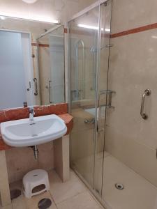 ein Bad mit einem Waschbecken und einer Glasdusche in der Unterkunft MAND CANTERAS in Las Palmas de Gran Canaria