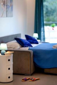 una cama con almohadas azules y un par de zapatos en el suelo en Holidays Homes The dream en Sant'Agnello