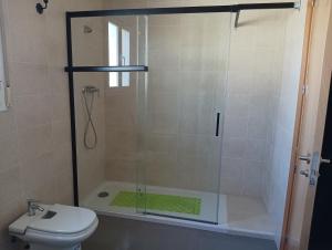 a shower with a glass door next to a toilet at Cazorlasalud in Santo Tomé