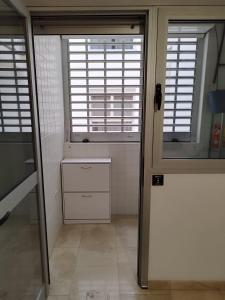 ein Badezimmer mit zwei Fenstern und einem weißen Schrank in der Unterkunft MAND CANTERAS in Las Palmas de Gran Canaria