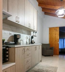 a kitchen with wooden cabinets and a couch in a room at Βίλα Σια in Rio