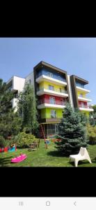 un gran edificio con un parque infantil delante de él en Golden Airport Residence en Otopeni