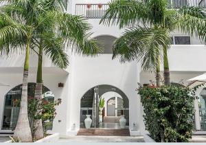 un edificio con dos palmeras delante en La Bella Vita Tulum, en Tulum