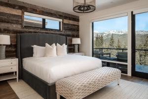 a bedroom with a bed and a balcony with mountains at 9 Deep Forest Drive by Moonlight Basin Lodging in Big Sky