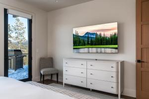 a bedroom with a bed and a dresser and a window at 9 Deep Forest Drive by Moonlight Basin Lodging in Big Sky +34 photos