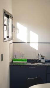 um balcão de cozinha com um lavatório e uma janela em Complejo Giraluna em Almafuerte